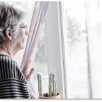 Vrouw kijkt triest uit het raam